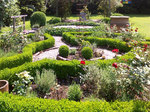 Gartenanlage mit parkähnlicher Bepflanzung: niedrige Hecken, Wege, Rosensträucher