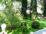 Garten mit Buchs, Zypressen und steinerner Engelfigur